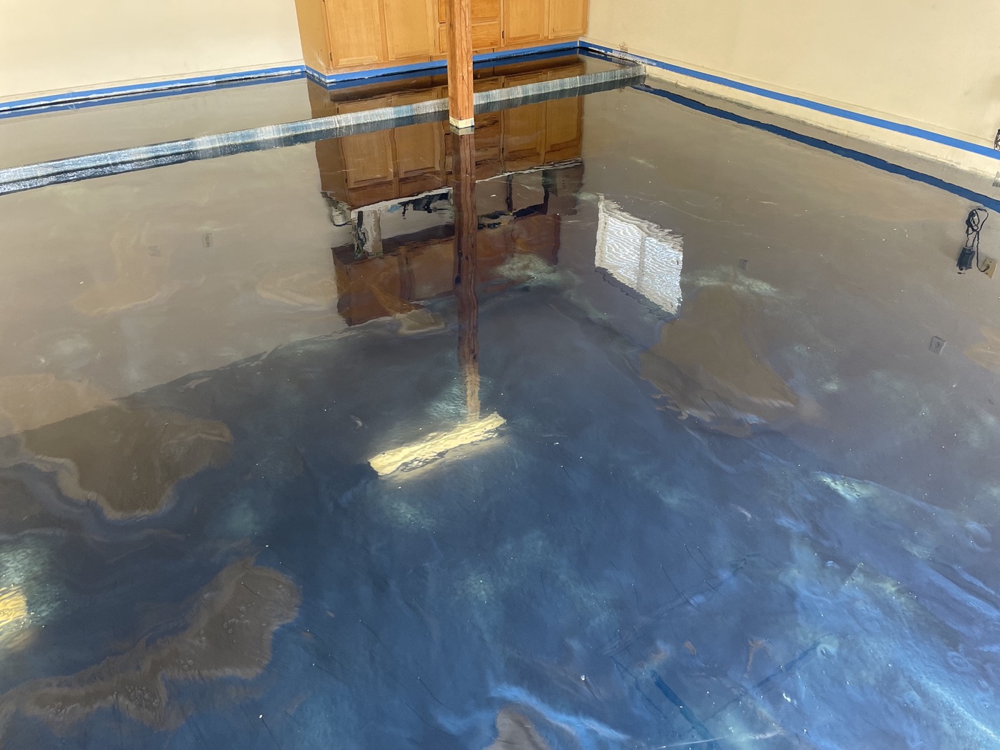 Wide view of blue and grey metallic movement across the residential garage floor