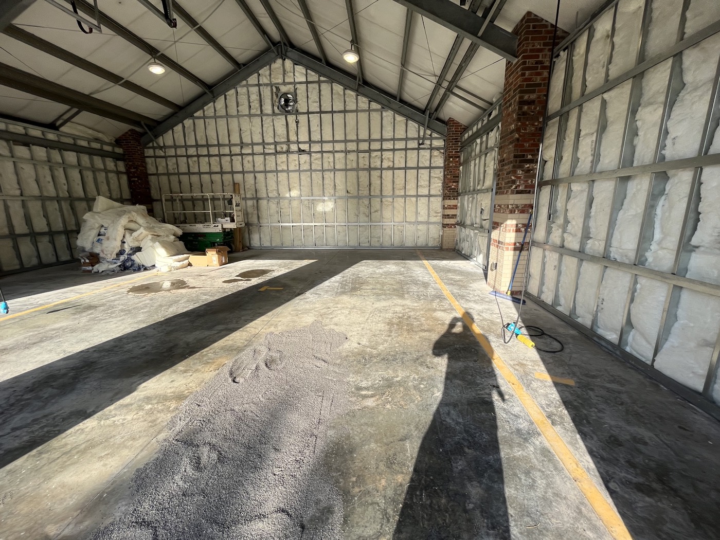 Fire station bay before the clear grind-and-seal installation, with lane markings and surface wear visible