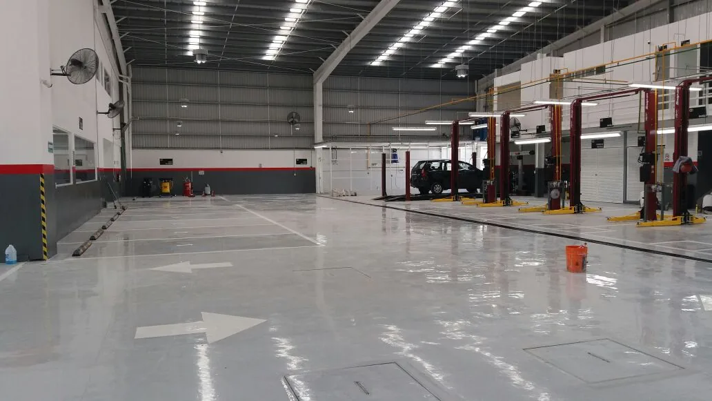 Bright grey resinous floor with traffic markings in an automotive service facility