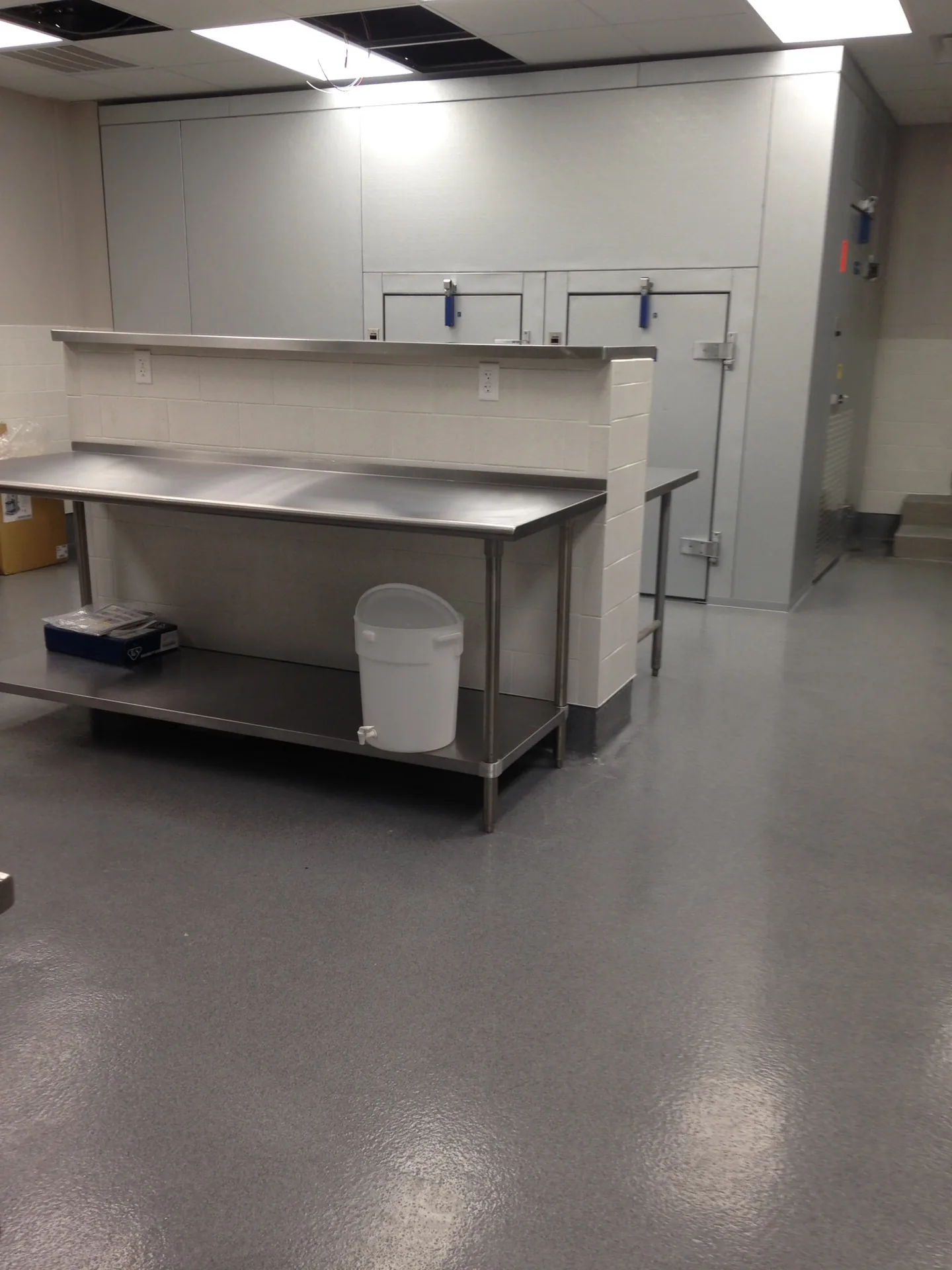 Seamless grey resinous floor with cove base in a commercial kitchen