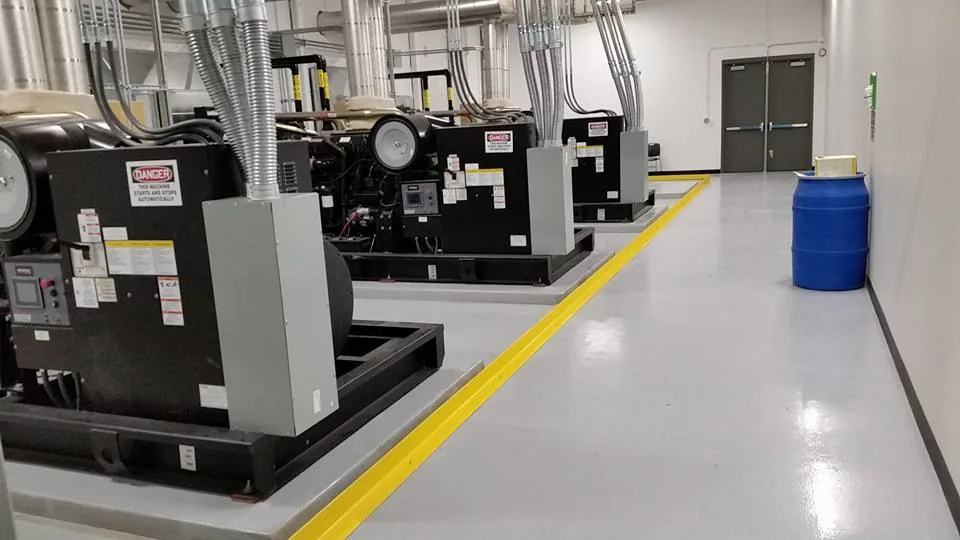 Grey industrial coating with yellow safety lines around mechanical equipment