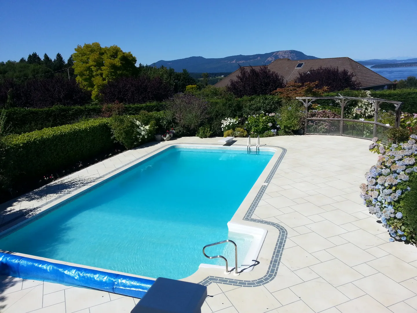 Light decorative concrete pool deck surrounding a blue residential pool