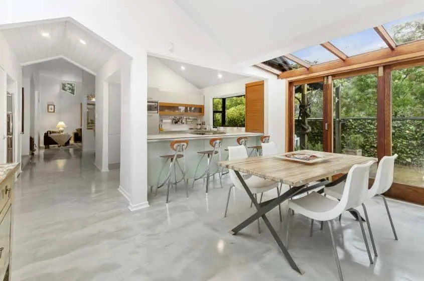 Light grey metallic concrete floor flowing through an open-plan home interior